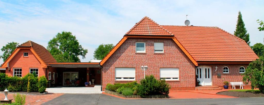 a brick house with an orange roof at Ferienwohnung Meyer in Surwold