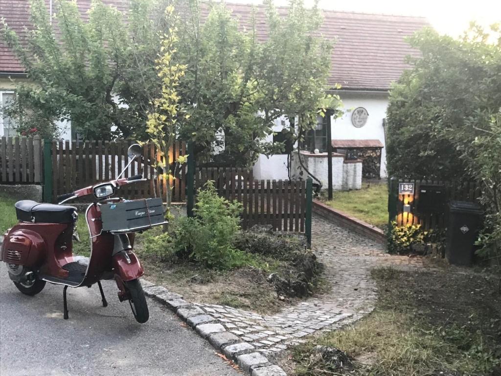 una moto roja estacionada frente a una valla en Gästehaus Nitsch, en Prinzendorf an der Zaya