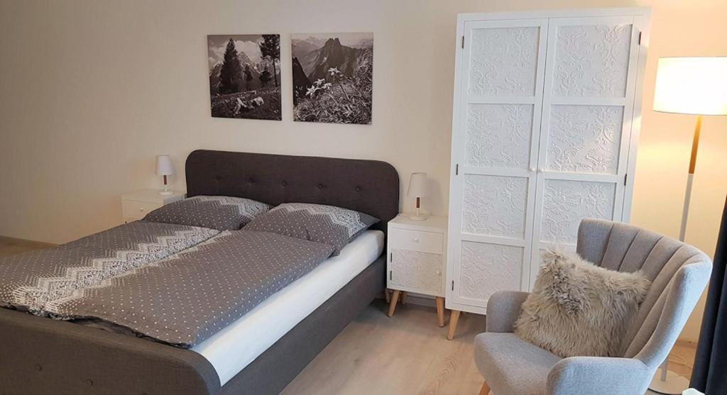 1 dormitorio con 1 cama y 1 silla en VILLA BERGAUF, Studio Apartment Kaiserin Elisabeth Sisi INKL KÖNIGSCARD !!, en Hohenpeißenberg