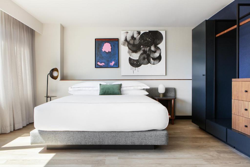 um quarto com uma grande cama branca e paredes azuis em Kimpton Banneker Hotel, an IHG Hotel em Washington