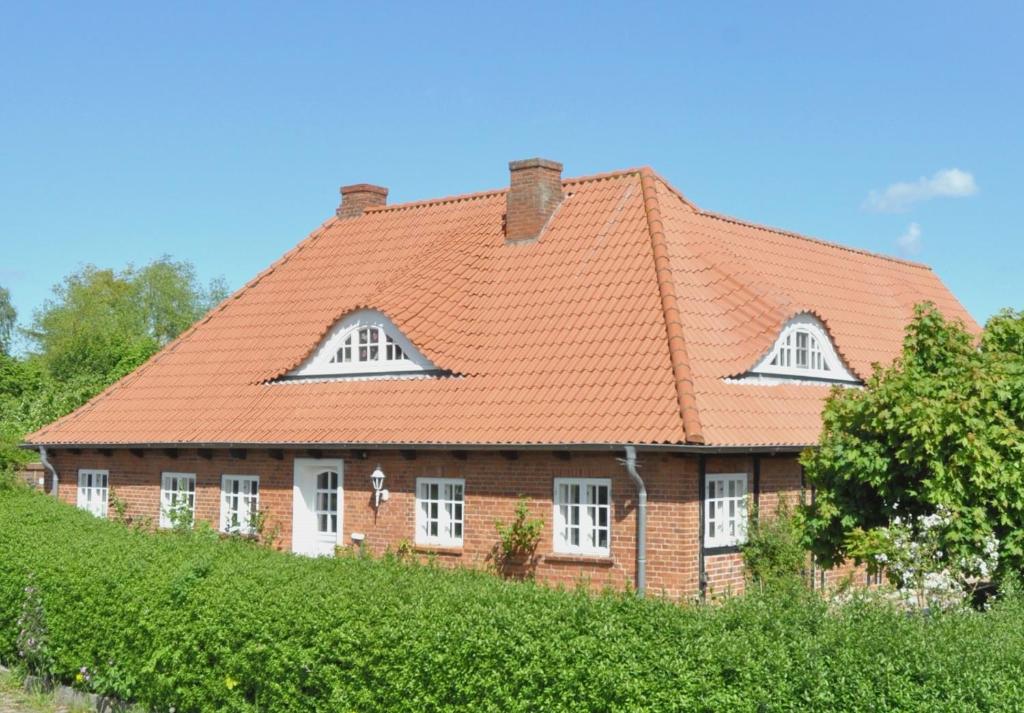 a brick house with an orange roof at Alte Stellmacherei - Ferienwohnung 2 in Riepsdorf