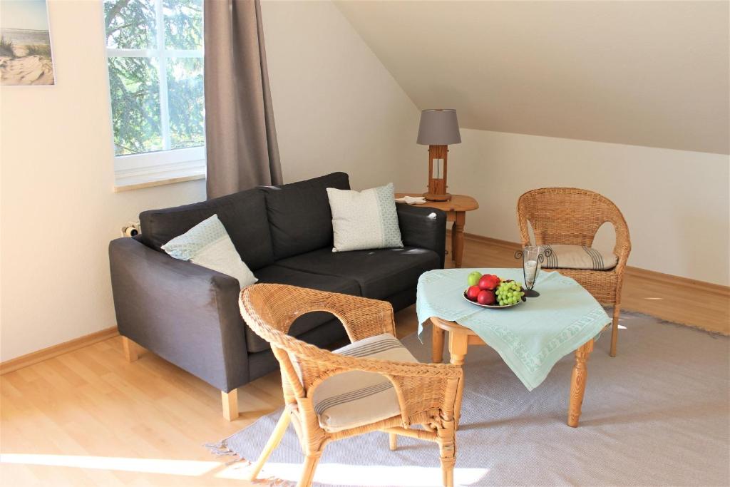 salon z kanapą, stołem i krzesłami w obiekcie "Pappelhof - Whg 4" w mieście Grömitz