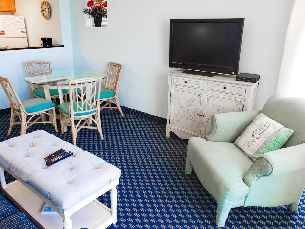 sala de estar con TV y mesa con sillas en Atlantica 901, en Myrtle Beach