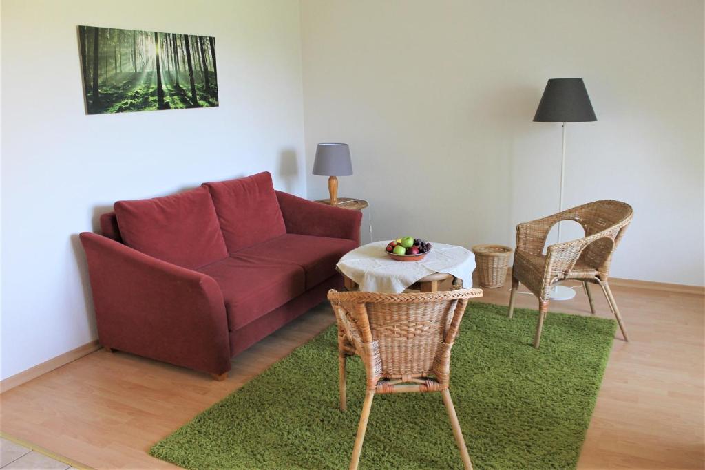 uma sala de estar com um sofá, uma mesa e cadeiras em "Pappelhof - Whg 9" em Grömitz