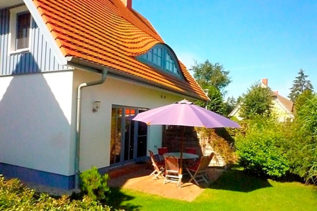 a patio with a table and a purple umbrella at Sonnenschein in Zingst
