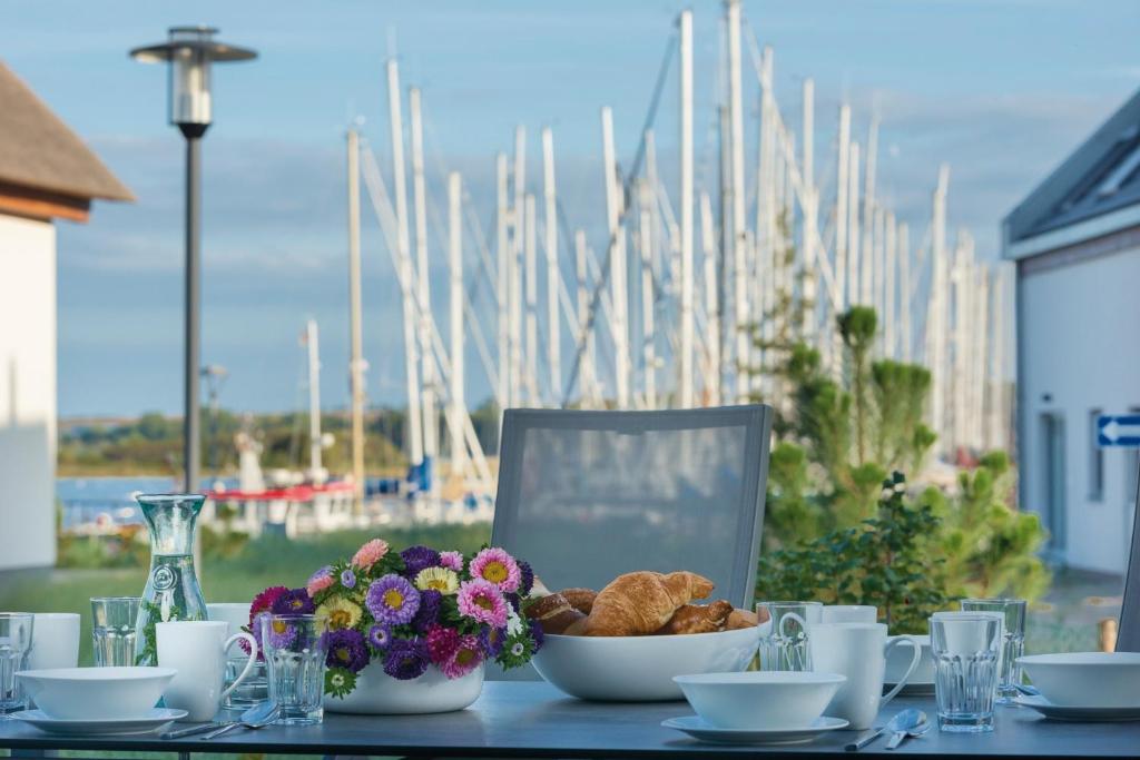 a table with a bowl of bread and flowers on it at Ostsee - Reetdachhaus Nr 36 "Warder" im Strand Resort in Heiligenhafen