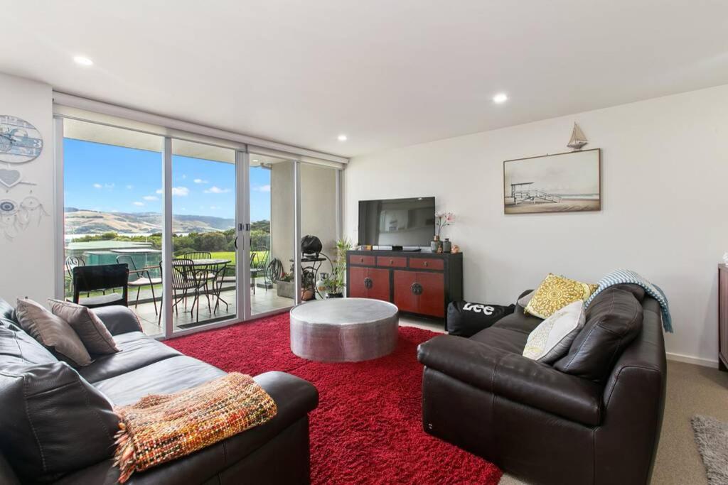 a living room with two leather couches and a red rug at Apollo Blue Pearl ~ Oceanfront ~ Free Wifi in Apollo Bay