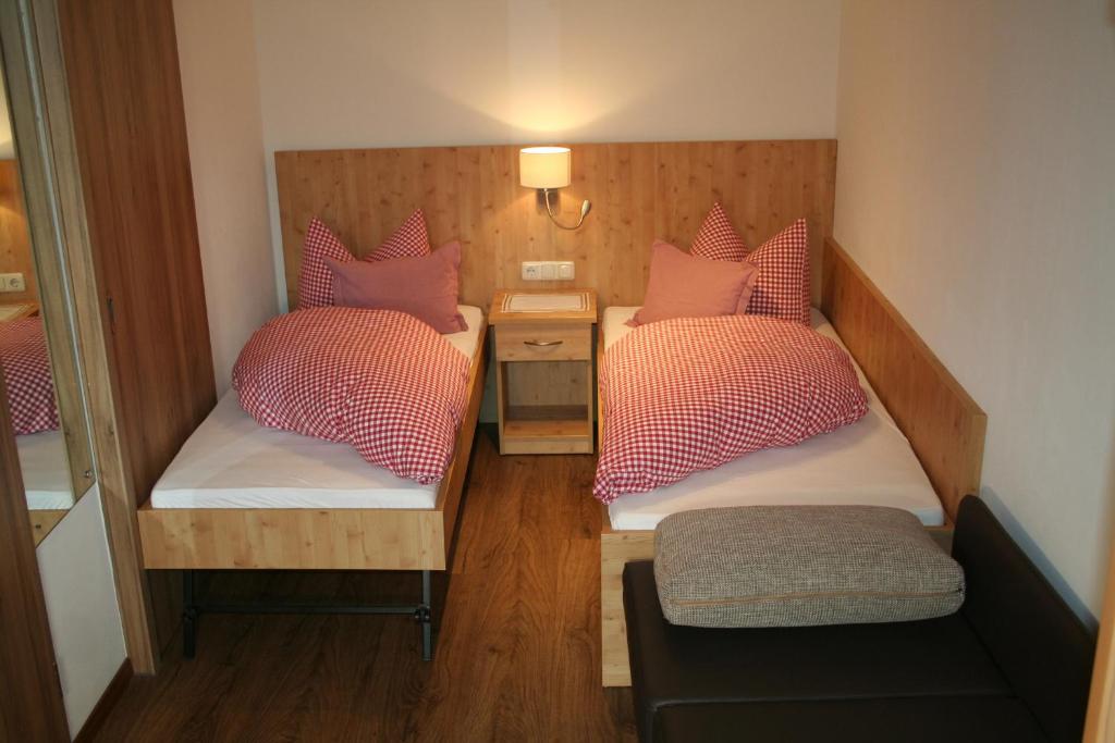 Habitación pequeña con 2 camas y almohadas rosas. en Fockenstein, en Bad Wiessee