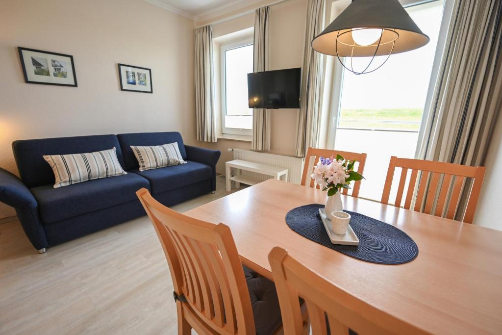 ein Wohnzimmer mit einem Tisch und einem blauen Sofa in der Unterkunft Zur schönen Aussicht - FW 5 in Dahme