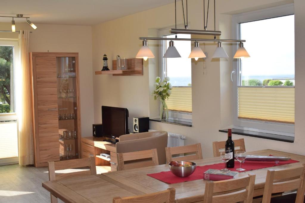 een eetkamer en een woonkamer met een tafel en stoelen bij Fehmarnstrand 78 RH 7 in Staberdorf