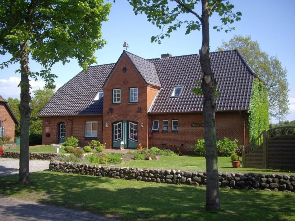 a large red brick house with a black roof at Hardina in Nieblum