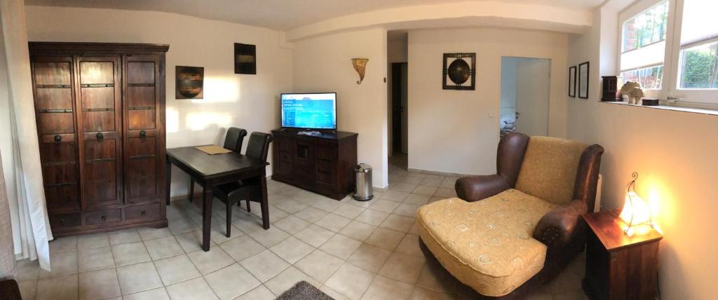 een woonkamer met een bank, een tafel en een televisie bij Hasen Apartment Lingen in Lingen