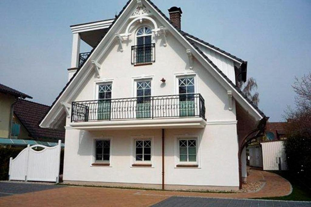 a white house with a balcony on top of it at Kapitän ParowBrigantine in Zingst
