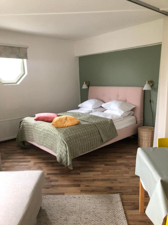 um quarto com uma cama grande e uma cabeceira rosa em Cosy apartment in the city center em Kemi