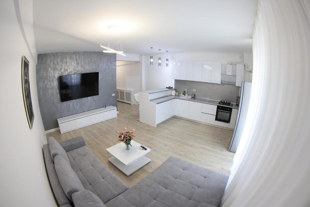 uma ampla sala de estar com um sofá e uma cozinha em Nicho Residence 2 Bucurestii Noi em Bucareste