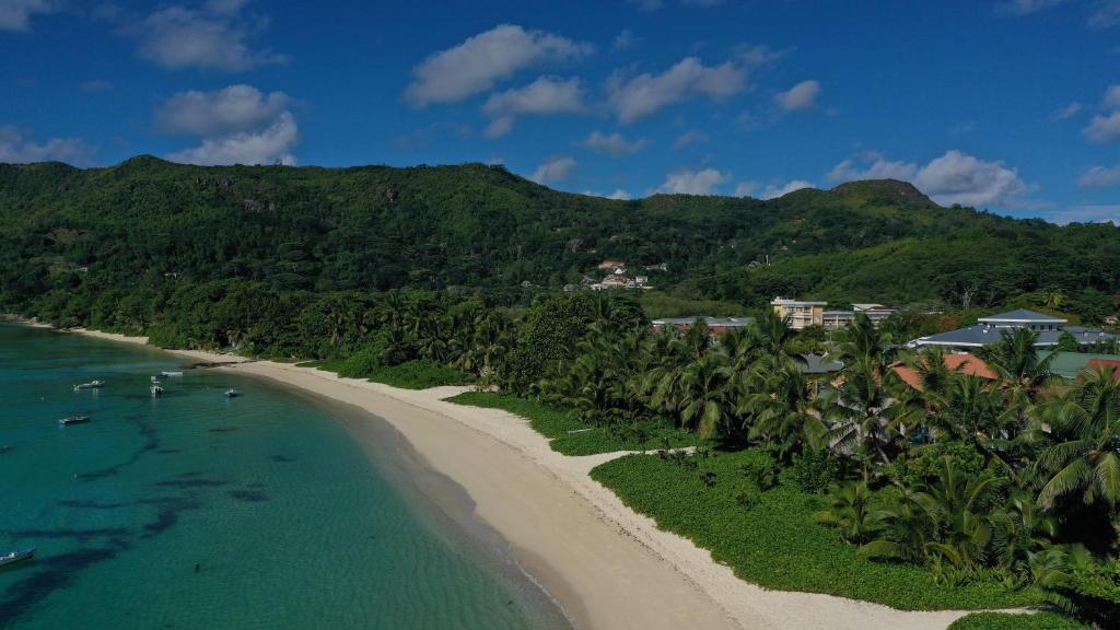an aerial view of a beach with palm trees at Pieds Dans L’Eau Holiday Apartments in Mahe