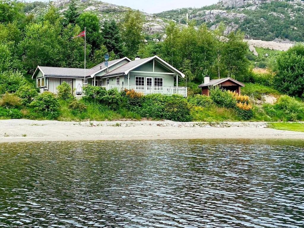 uma casa na costa de um corpo de água em 8 person holiday home in j rpeland em Jorpeland