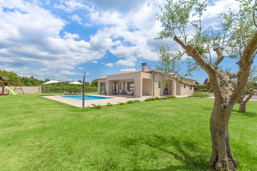 a villa with a swimming pool and a green yard at Spacious New design Villa Vitis Vitae, private pool ,1400m2 garden , Central Istria in Svetvinčenat