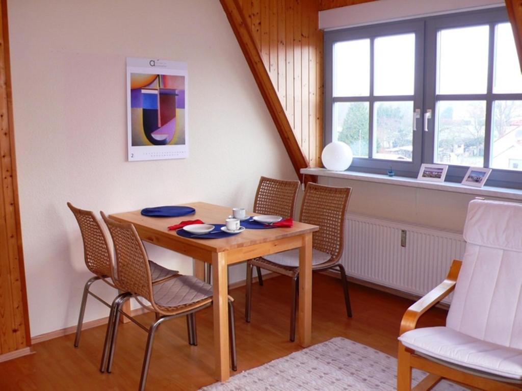 uma sala de jantar com mesa e cadeiras em Ferienwohnung Uferschwalbe em Rerik