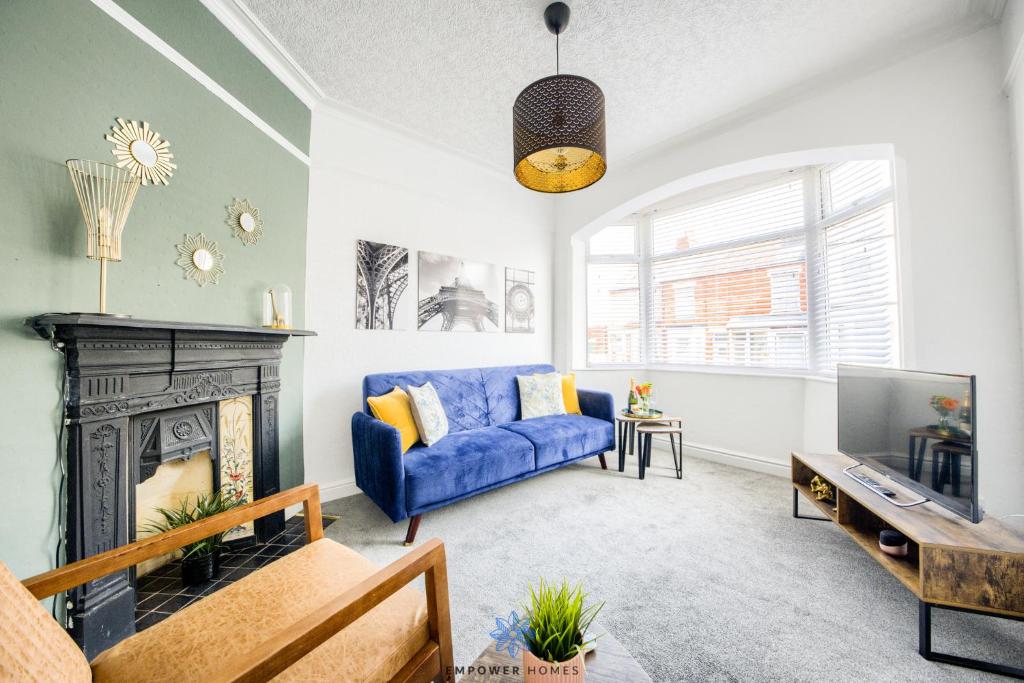 a living room with a blue couch and a fireplace at Coventry Stylish House, City Centre, Free Parking, Sleeps 5, by EMPOWER HOMES in Spon End