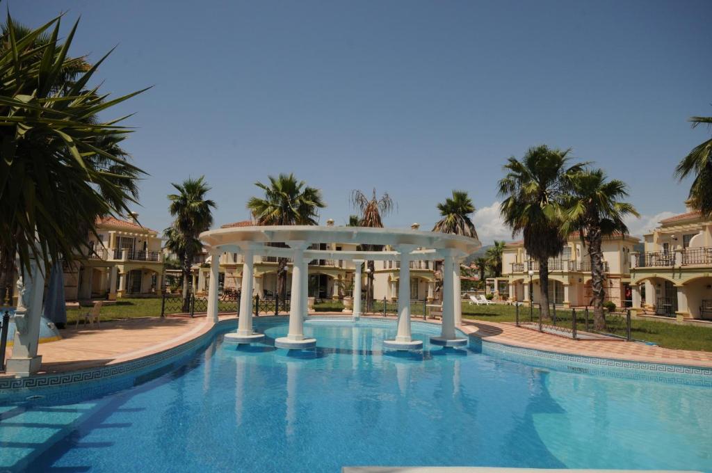 a swimming pool with a gazebo and palm trees at Villa B & D in Fethiye