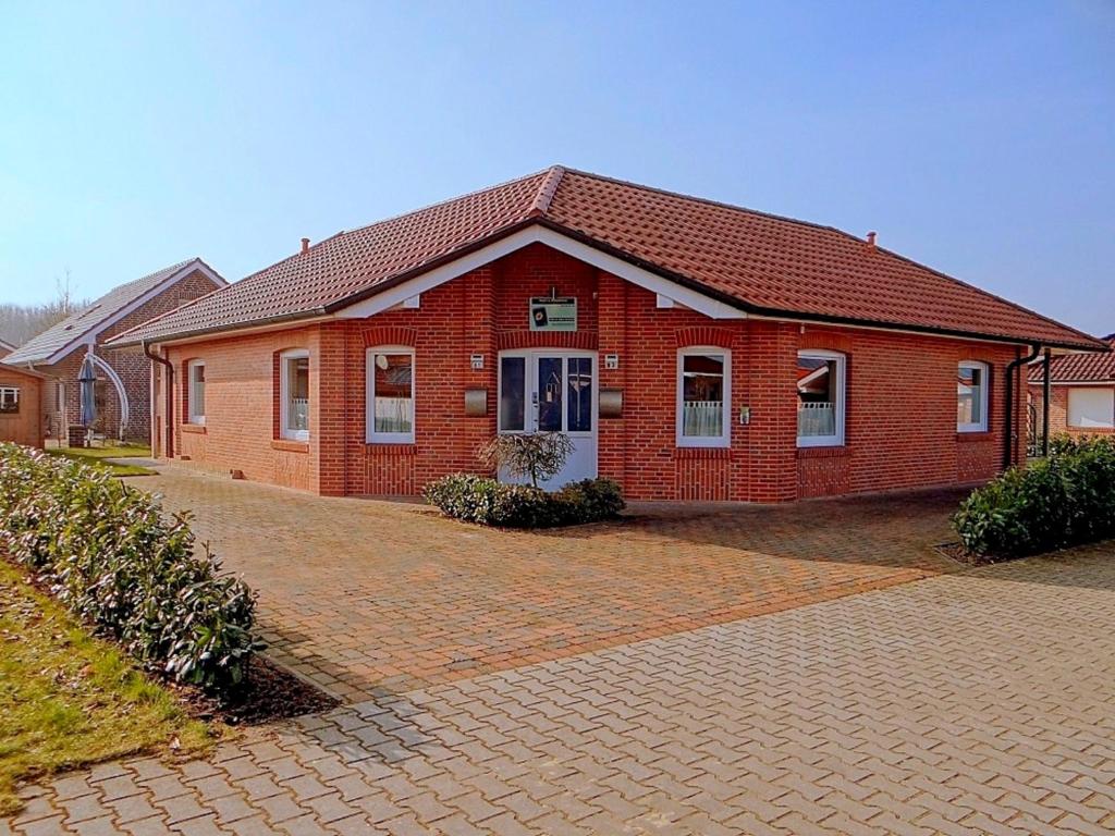 une maison en briques rouges avec une allée en briques dans l'établissement Nicky's Ferienhaus, à Geeste