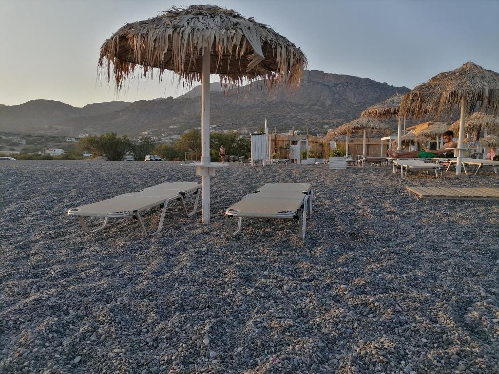 plaża z 2 krzesłami i słomianym parasolem w obiekcie On the beach w mieście Koutsounari