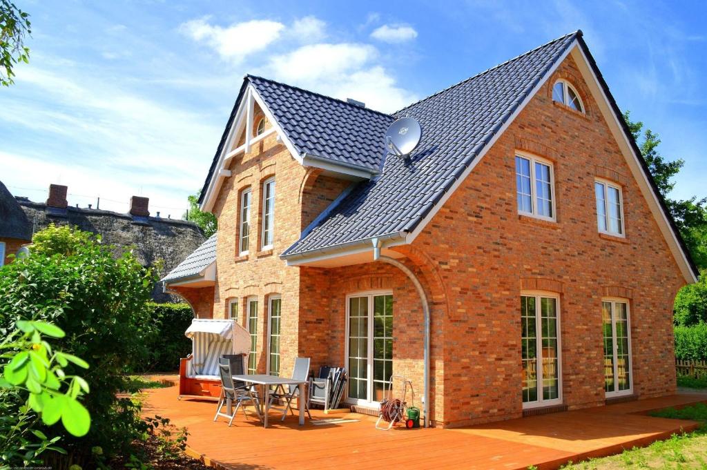 a brick house with a roof on a patio at Dreamhus Borgsum in Borgsum
