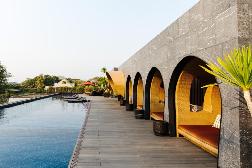 A long rooftop-style pool deck with built-in shaded seating.