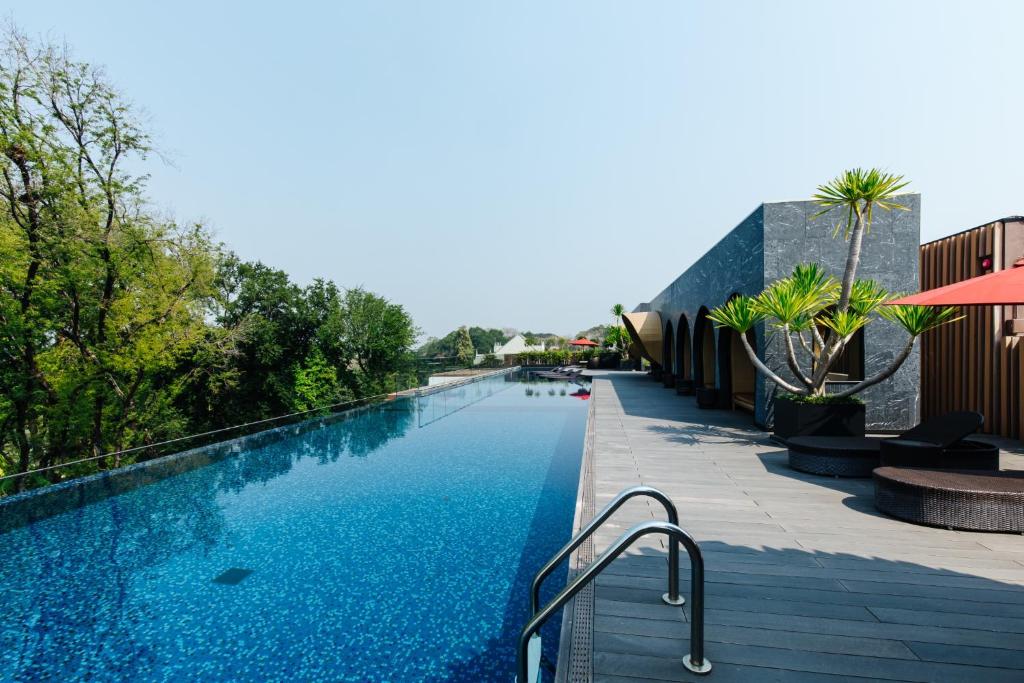 A long infinity-style pool stretches along a sunny rooftop or upper-level deck.