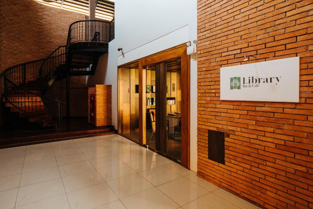 A bright interior entrance to the hotel library beside a spiral staircase.