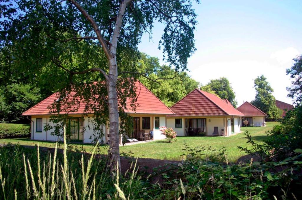 una casa con techo rojo y patio en Ferienhof Rauert Haus 4, en Todendorf auf Fehmarn