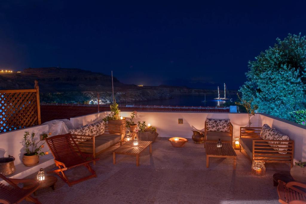 a patio with furniture and lights at night at Elegant-Lindian Villa Marietta in Líndos
