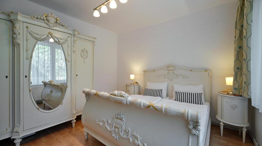 1 dormitorio con 2 camas y un espejo grande en Fövenyes House Grande en Balatonudvari