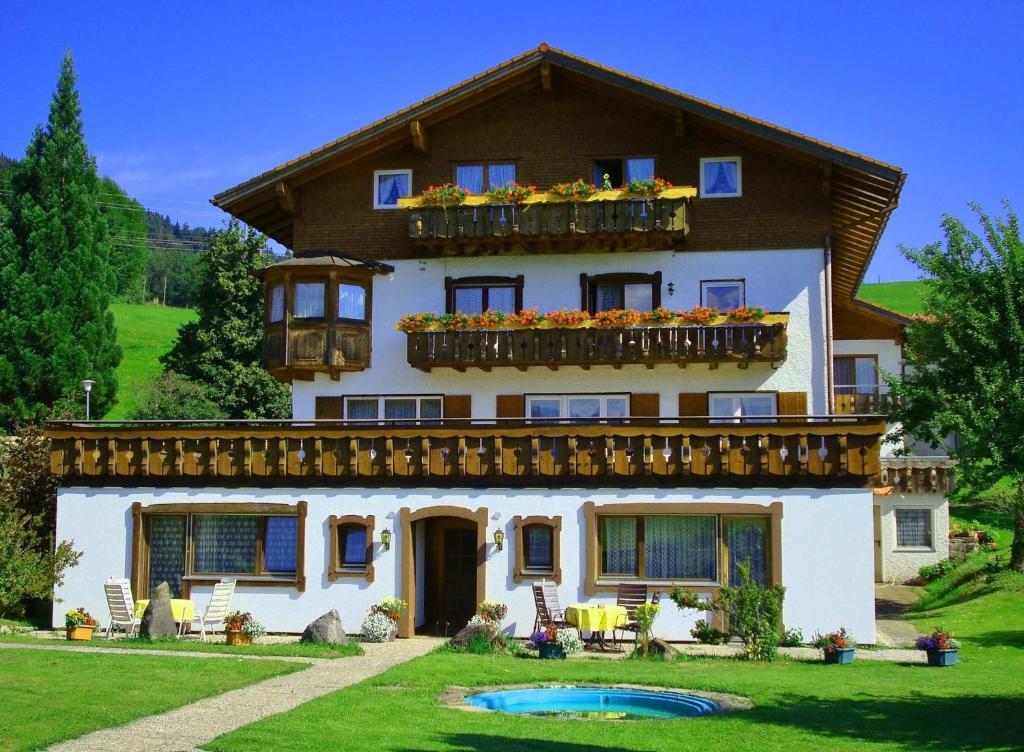 une maison avec une piscine en face de celle-ci dans l'établissement Trettach, à Ofterschwang