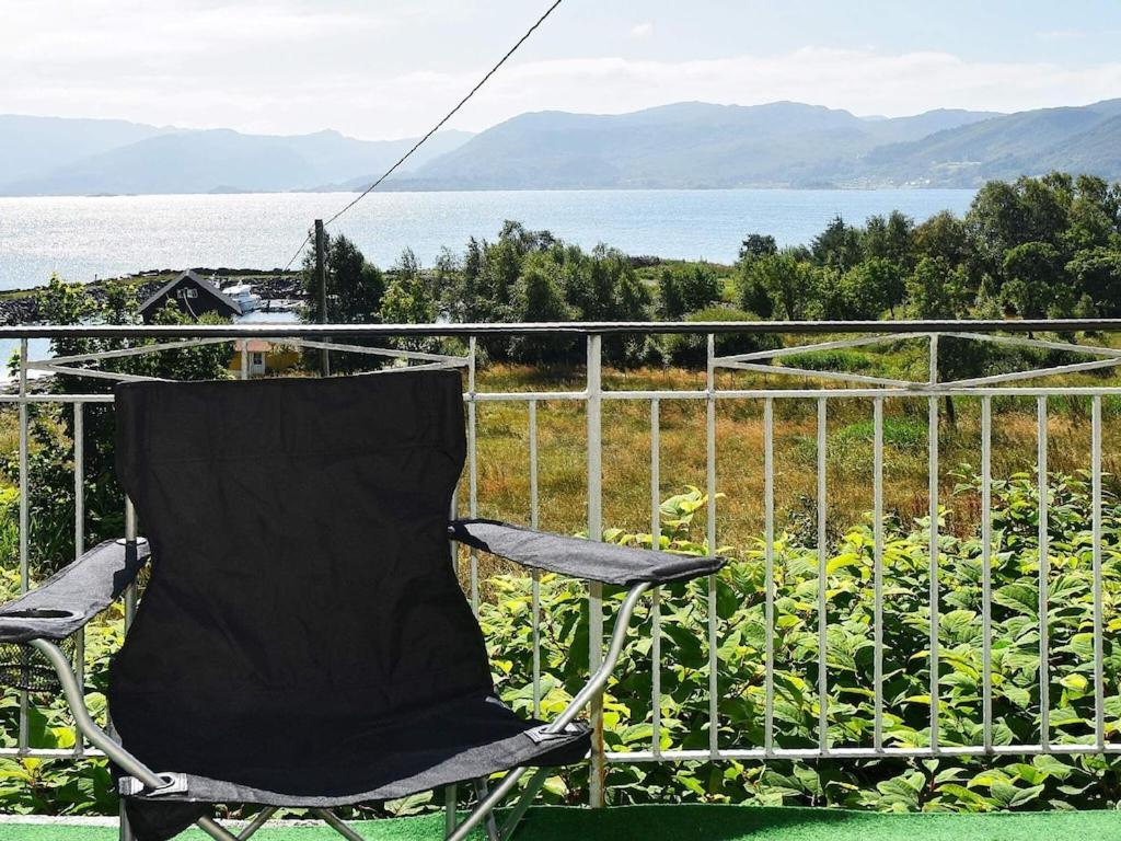 a chair sitting on a balcony overlooking the water at 6 person holiday home in FISK in Fiskå