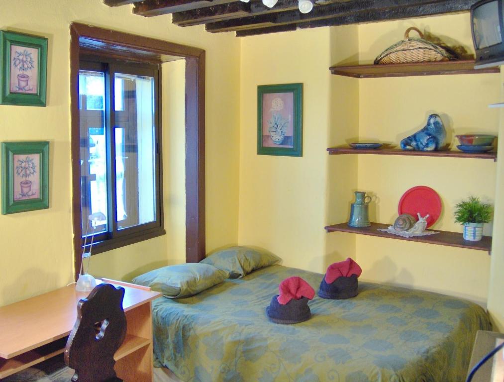 Una habitación con una cama con sombreros. en Kleines Einzelzimmer mit Meerblick, en Icod de los Vinos
