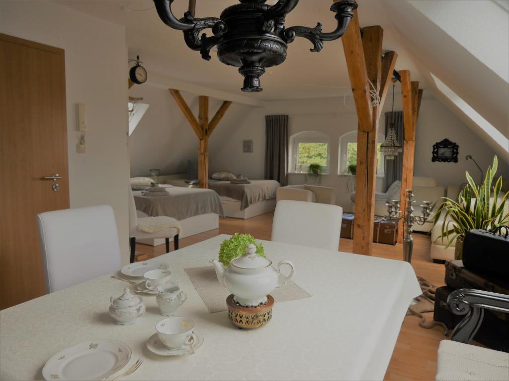 a dining room with a table with a tea pot on it at Ferienwohnungen im Alten Bahnhof in Osnabrück