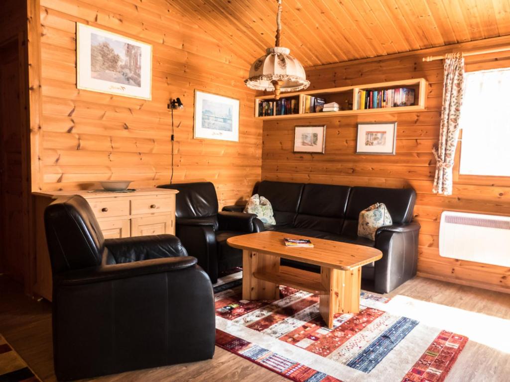 ein Wohnzimmer mit Ledermöbeln und einem Tisch in der Unterkunft Ferienhaus Nr 24, Typ A, Feriendorf Jägerpark, Bayerischer Wald in Viechtach