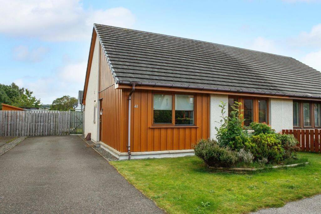 una casa marrón y blanca con una valla en Modern 2 Bedroom Semi detached House with own private driveway en Inverness