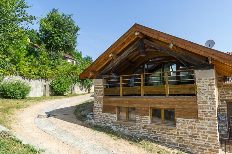 a brick building with a balcony on a dirt road at Gîte de l'Arche - gitesdesbalcons-com in Panossas