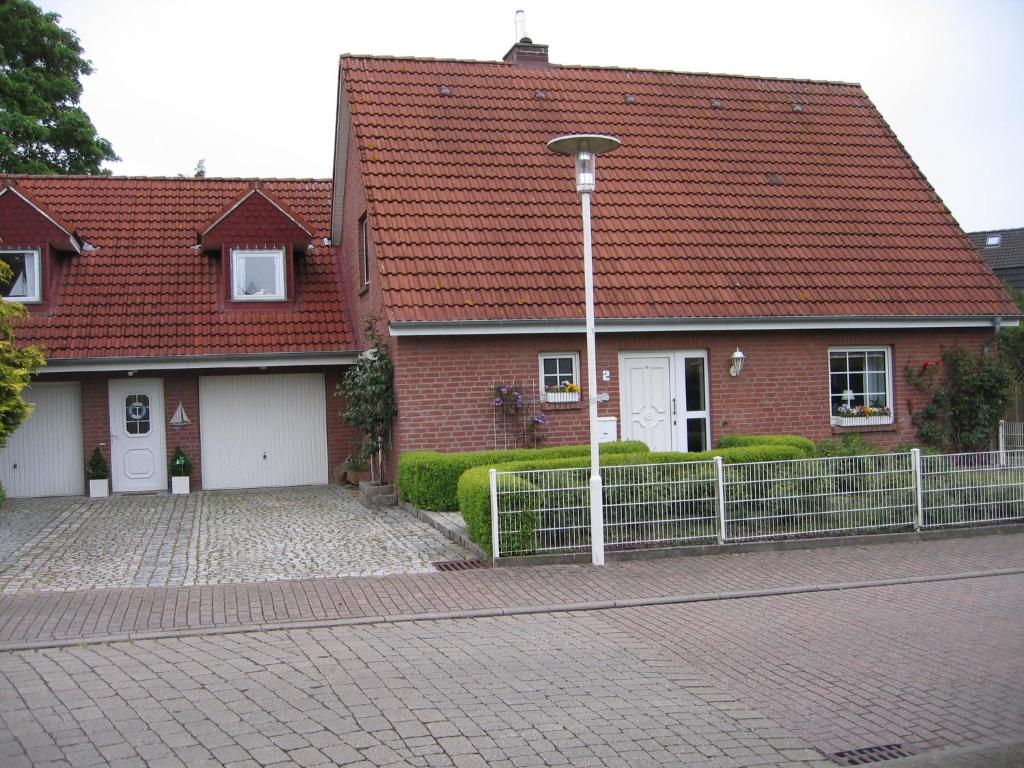 a brick house with a red roof and a street light at Kinderfreundliche Ferienwohnung - Am Hufen 2 in Grömitz