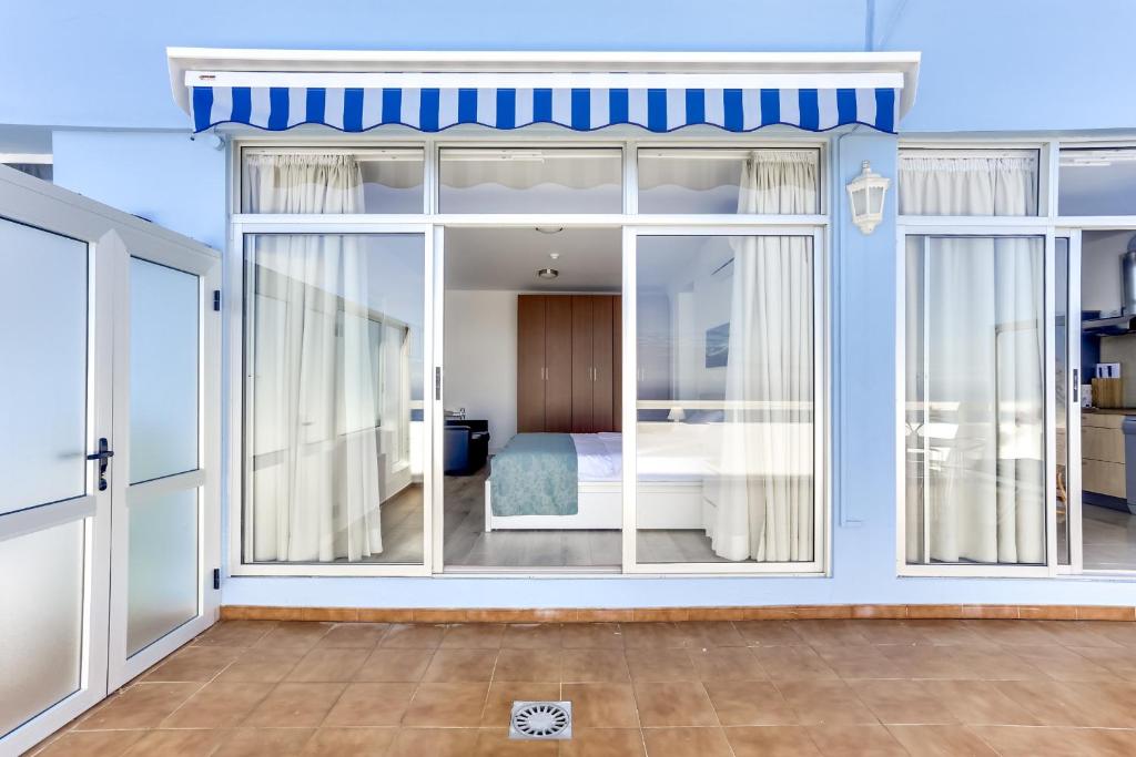 プエルト・デ・ラ・クルスにあるPenthouse 1804 mit wundervollem Blick im Precise Resort Tenerifeのガラスの引き戸付きの部屋、ベッドルーム1室が備わる客室です。