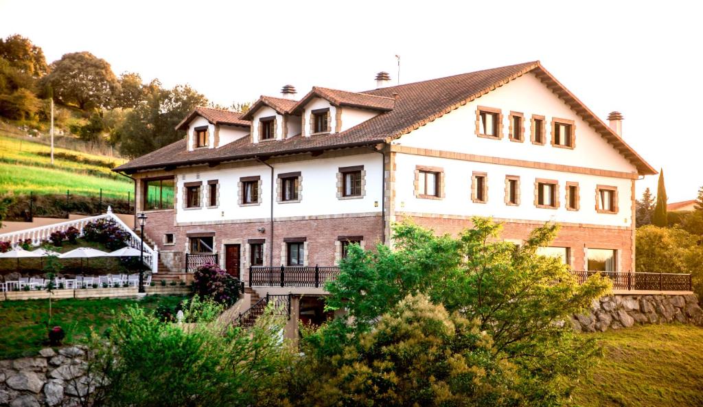 a large house on top of a hill at Hotel Peñas Blancas in Liaño