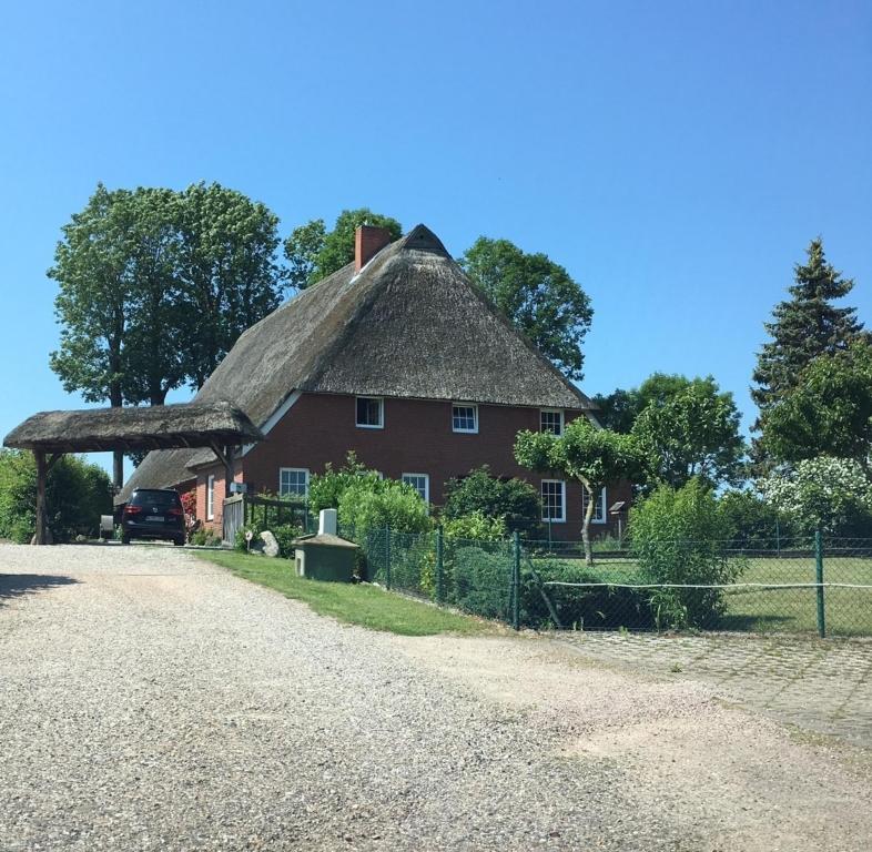 Casa roja grande con techo de paja en Stockrose en Schashagen