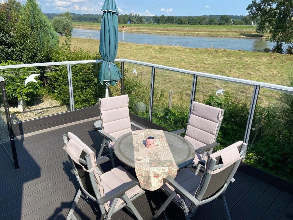 einen Tisch und Stühle auf einer Terrasse mit einem Sonnenschirm in der Unterkunft Chalet Silas in Lathum