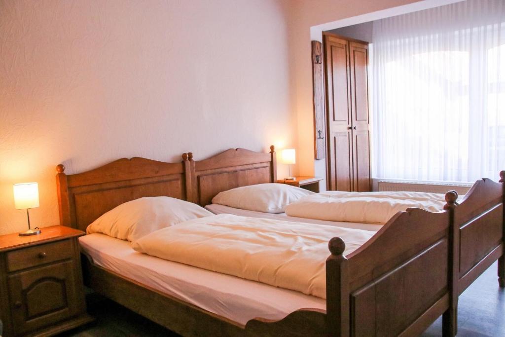 2 camas individuales en un dormitorio con ventana en Familienhof Brüning - Doppelzimmer Waldesruh I, en Meppen