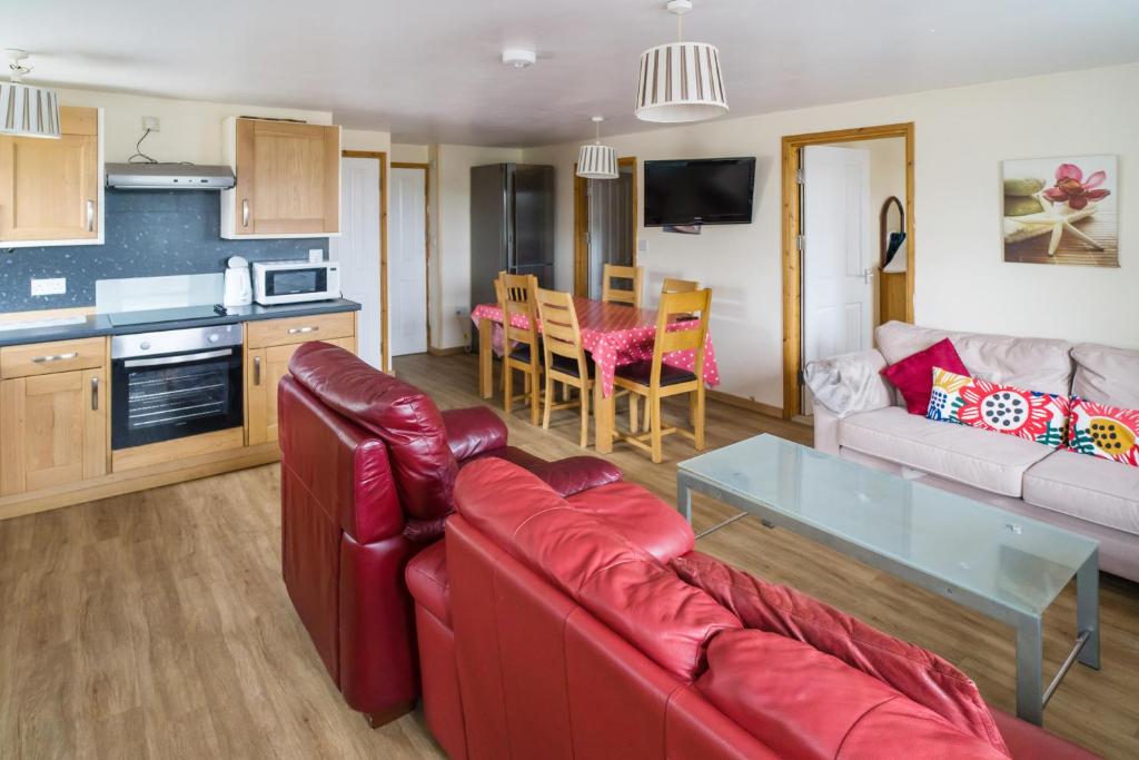 a living room with a red couch and a table at The Pine Lodge in Aberystwyth