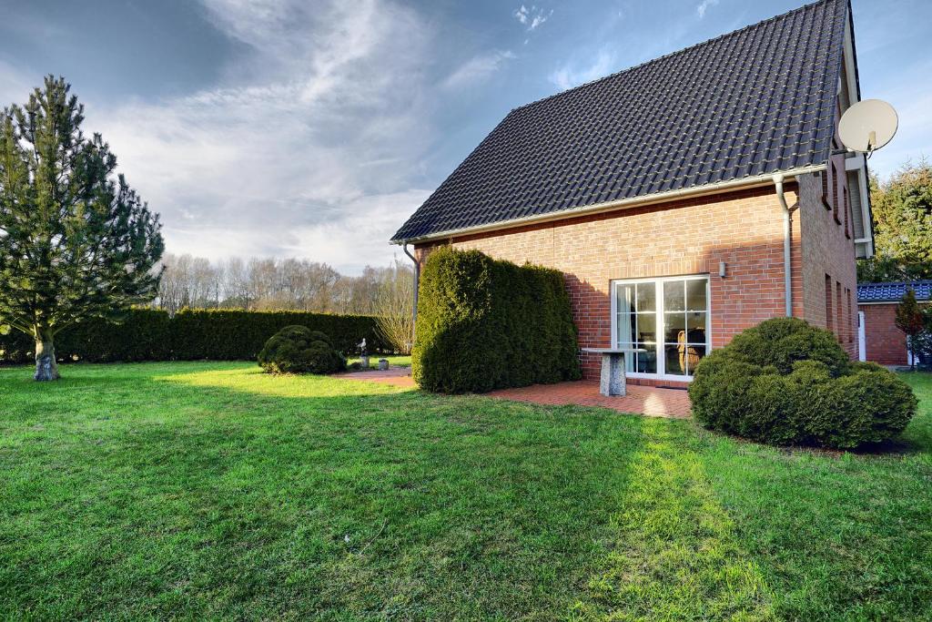 a brick house with a window and a grass yard at Edda in Zingst