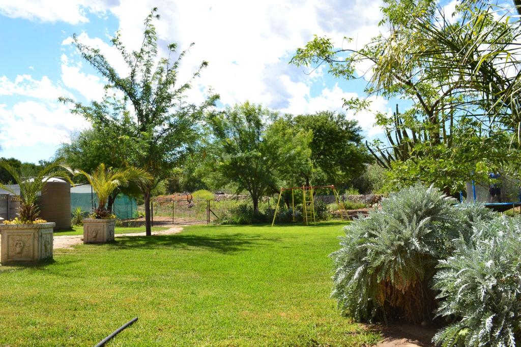 un parque con un parque infantil con árboles y plantas en Stay@51 Botha, en Oudtshoorn